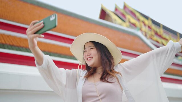 Asian woman traveler taking selfie photo in the famous temple in Bangkok city. Travel Thailand Concept.