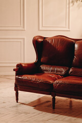 Vertical photo leather sofa, artificial light, antique furniture. Live white interior