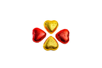 Heart shaped chocolate hearts wrapped in red and gold (yellow) foil on white background