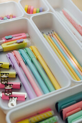 Stylish colored stationery in pastel colors is arranged in white organizers. Creative Drawer Organizing. Storage office supplies. Concept back to school.