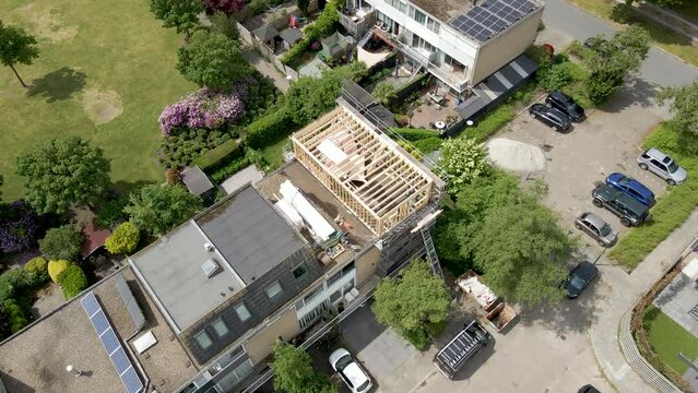 Aerial overview of wooden frame of roof structure under construction in a suburban neighborhood
