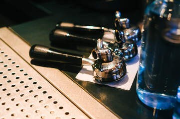 Holders from coffee machine for brewing coffee on bar counter table, close up.
