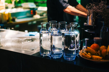 Glass bottles with water on the bar counter in asian restaurant.