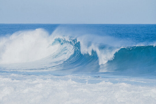 A big blue beautiful ocean wave crashing down