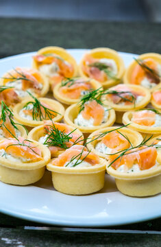 Small smoked salmon and dill tarts on a plate