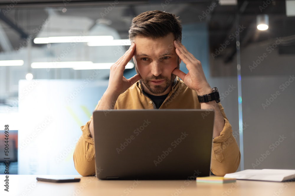 Poster businessman using laptop suffering from headache having problems in office