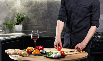 handsome, strong, sexy man in the kitchen preparing dinner