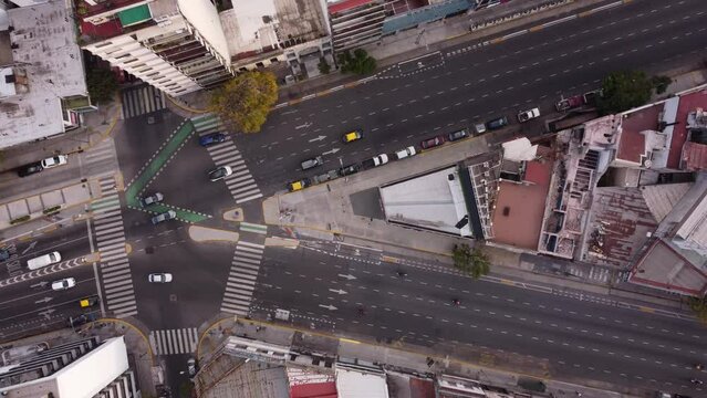 Aerial top down of vehicles diverting towards different lanes from intersection at Cordoba Avenue fork. Buenos Aires, Argentina.