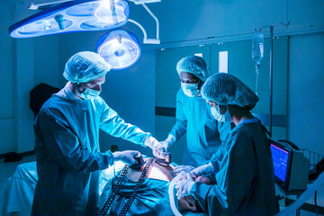 Team of surgeon doctor using defibrillator to give electrical shock to patient heart who is...