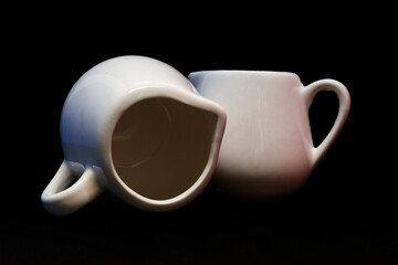 Two little creamers on a black background