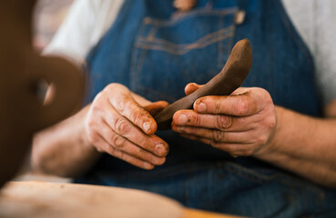 Anonymous craftswoman artisan shaping piece of clay ceramic in hand