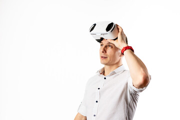 A successful man in a white vr helmet in a white shirt looking up on a white background.