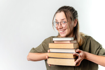 Young happy woman student holding books by her face on white background