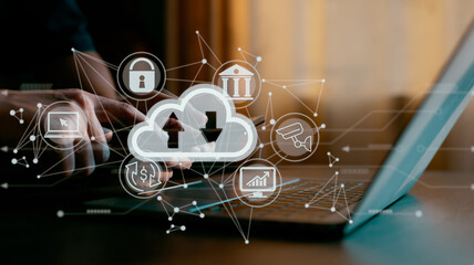 Fototapeta premium A guy works on a laptop while holding a cloud computing diagram. Concepts of cloud computing, data storage, networking, and internet services.