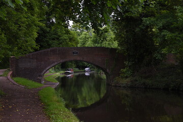 Fototapeta na wymiar the arch bridge that goes over the canal in Stourton with a canal boat on the side of the canal