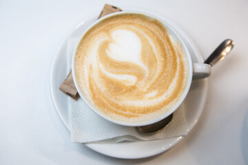 Serving latte in a cafe. Cup napkin spoon and sugar.
