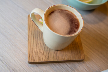Serving latte in a cafe. Cup napkin spoon and sugar.