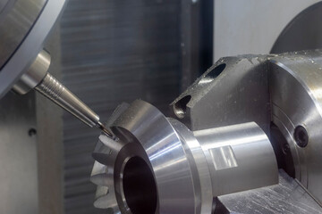 The 5-axis CNC milling machine  cutting the metal gear part.