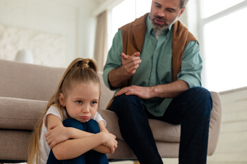 Strict Father Scolding Sad Little Daughter Sitting At Home