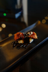 Japanese food : Unagi Sushi is The rice is made into bite-sized pieces, and the grilled eel is placed in a special sauce ฟืก placed on a black plate