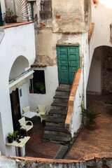 Fototapeta na wymiar Сozy little town on the Amalfi Coast - Cetara. Lovely old traditional courtyards with stairs. Summer seaside resort. Holidays in the south of Italy. European tourism.