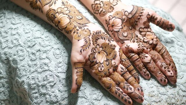 women applying henna on hand 