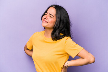 Obraz premium Young hispanic woman isolated on purple background suffering a back pain.
