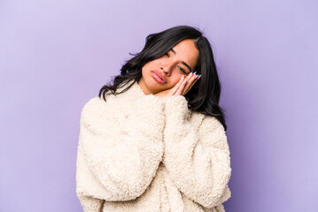 Young hispanic woman isolated on purple background yawning showing a tired gesture covering mouth with hand.