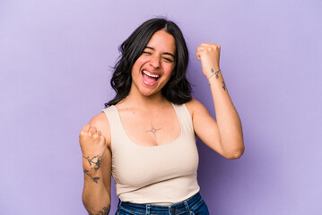 Young hispanic woman isolated on purple background cheering carefree and excited. Victory concept.
