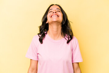 Young hispanic woman isolated on yellow background relaxed and happy laughing, neck stretched showing teeth.