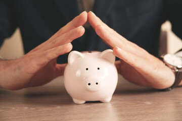 Man putting coin in piggy bank. saving money, finance concept