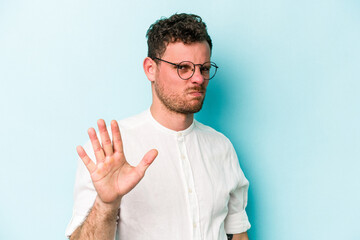 Young caucasian man isolated on blue background rejecting someone showing a gesture of disgust.