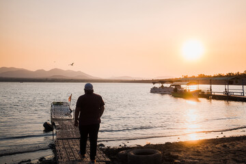 Fototapeta premium Man on dock lakeside sunset in Mexico
