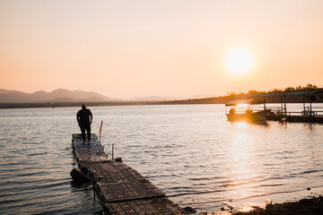 Fototapeta na wymiar Man on dock lakeside sunset in Mexico
