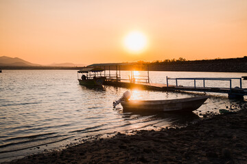 Fototapeta na wymiar Boats docked at lake at sunset in Mexico