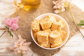 Traditional turkish delight (rahat lokum) with glass of green tea on a white wooden background. top view, close up.