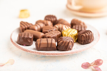Chocolate candies with cup of coffee. side view, selective focus.