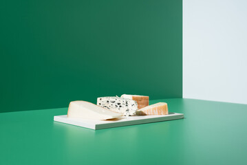 Surtido de quesos franceses. Queso de leche de cabra, vaca y oveja sobre un fondo verde	