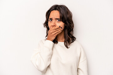 Young hispanic woman isolated on white background covering mouth with hands looking worried.