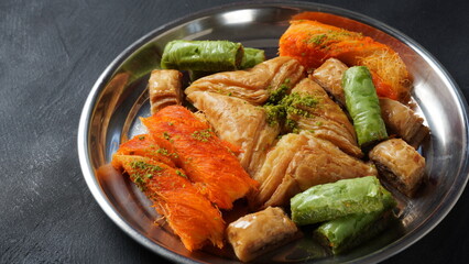 A tray of Turkish pastries including baklava, knafeh -  a Middle Eastern cheese pastry soaked in sweet, sugar-based syrup