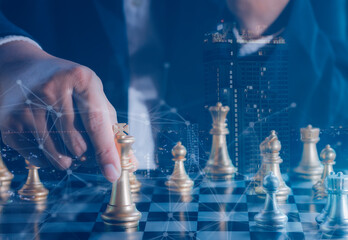 Hand of businessman holding gold king chess on stock market or forex trading graph chart with cityscape image economy trend for digital financial investment.Management or leadership strategy concept.