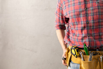 Fototapeta na wymiar Construction worker man with tool belt house room renovation. Male hand and construction tools