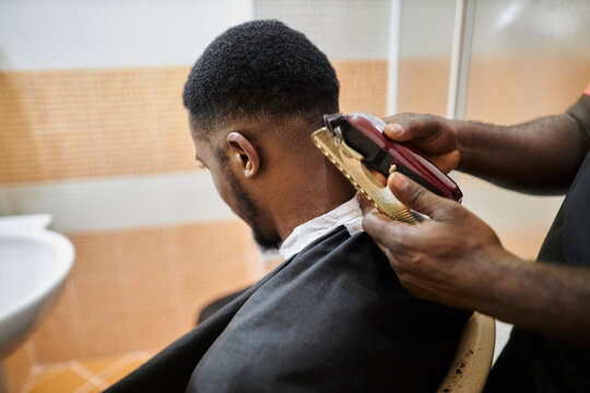 african american hairdresser cuts an african american man's hair with a clipper. clipper haircut