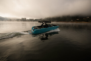 Fototapeta premium bright blue motorboat quickly floating on the water