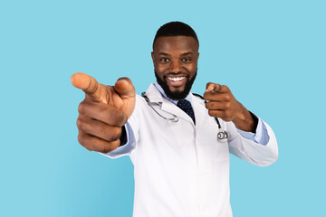 Cheerful African American Male Doctor In Uniform Pointing Fingers At Camera