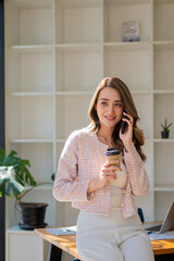 Asian businesswoman talking on a smartphone in front of a document desk Financial graph with desk calculator and laptop for modern vertical vertical ecommerce marketing idea.