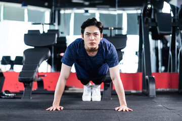 Fototapeta na wymiar Young man in sportswear exercising at the gym