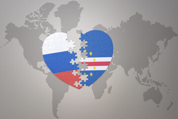 puzzle heart with the national flag of russia and cape verde on a world map background. Concept.