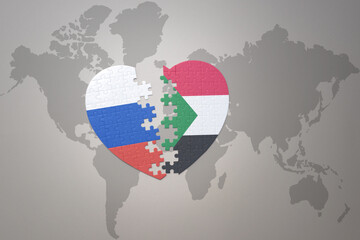 puzzle heart with the national flag of russia and sudan on a world map background. Concept.