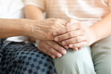 Young and senior woman holding each other hands togetherness concept. Elderly care and protection with love from grandchild.